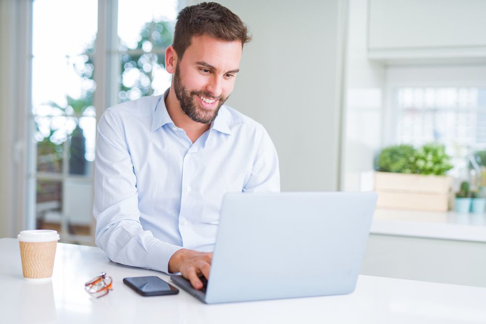 مرد جوان بیکار در حالی که به دنبال کار است با نوشتن یک پست وبلاگ در حال حضور آنلاین است